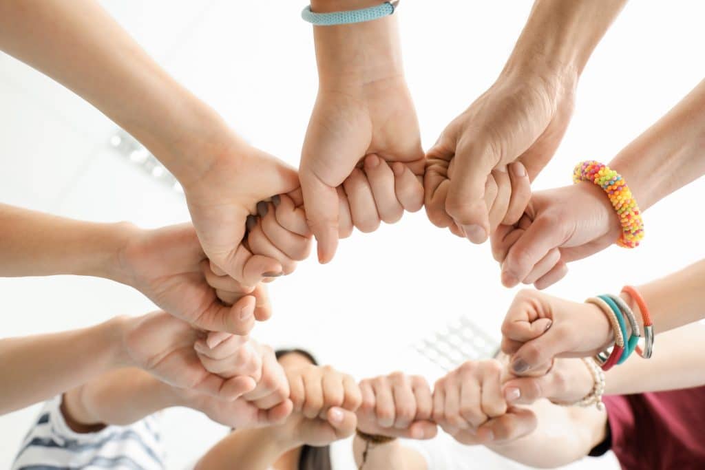 Groupe de personnes assemblant leurs poings en signe d'unité